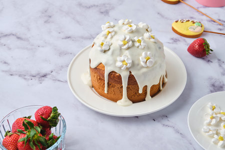 Cake filled with custard and strawberries covered with white icing and decorated with marshmallow...
