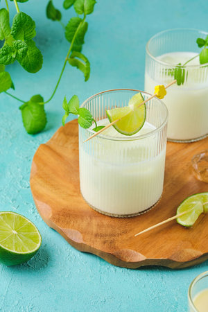 Refreshing drink, Brazilian lemonade made of lime and condensed milk with ice cubes in transparent...