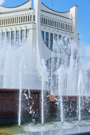 Jets of water in a city fountain in the city center in the summer in sunny weather. A place for citizens to relax.の写真素材