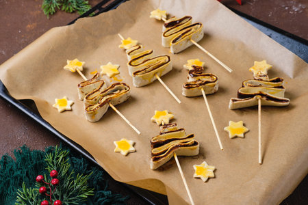 Prepared for baking sweet and salty puff pastry Christmas trees with filling on a baking sheet on a...