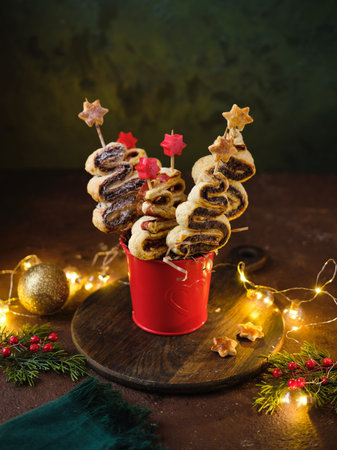 Baked sweet and salty puff pastry Christmas trees with chocolate spread or ham and cheese filling in...