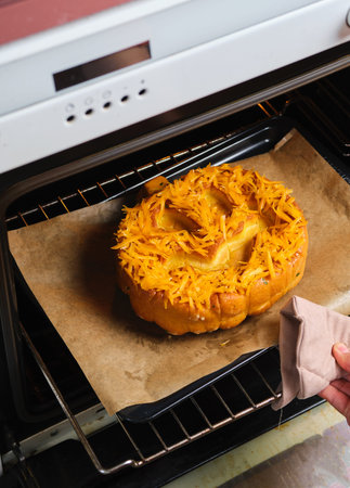 Step by step recipe for pumpkin bread shaped like a Halloween jack-o'-lantern on a dark concrete background. Halloween-themed baking. Holidays around the world. Step-by-step recipes.の写真素材