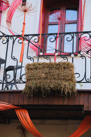 Autumn outdoor decorations made from dried plants and hay bales on the street.