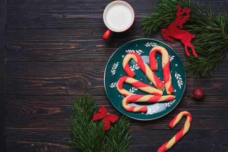 Christmas candy cane shortbread cookies on a green plate with Christmas decor against a dark wooden background. Merry Christmas. Traditional Christmas treats.の写真素材