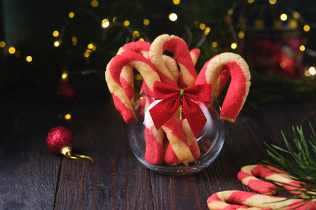 Christmas candy cane shortbread cookies in a clear glass vase with Christmas decor on a dark wooden background. Merry Christmas. Traditional Christmas treats.の写真素材