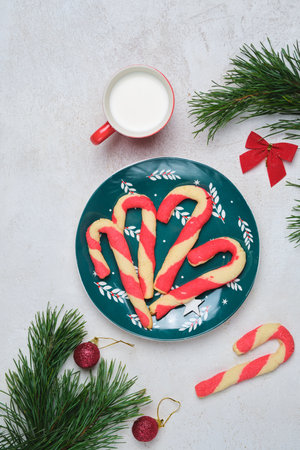 Christmas candy cane shortbread cookies on a green plate with Christmas decor against a white concrete background. Merry Christmas. Traditional Christmas treats.の写真素材