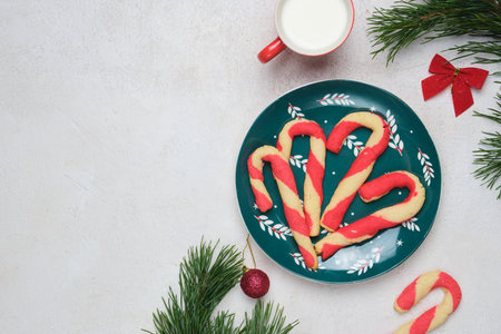 Christmas candy cane shortbread cookies on a green plate with Christmas decor against a white concrete background. Merry Christmas. Traditional Christmas treats.の写真素材