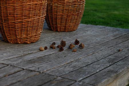 Baskets with wood and pine cones on wooden backgroundの写真素材