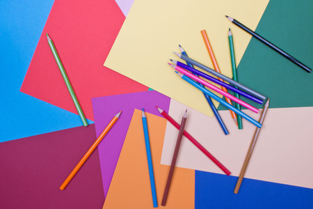 background of differently colored papers and pencils 