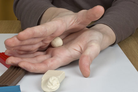 Boy moulds from plasticine on table