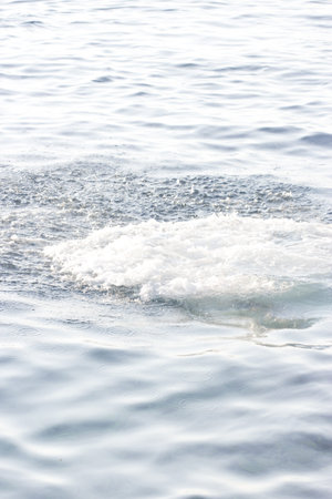 close-up of white sea splashes on blue water background 