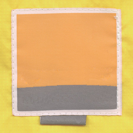 yellow-black textile label  on yellow fabric background