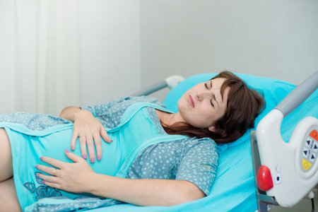 Pregnant woman in labor on a functional bedの写真素材