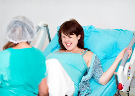 Pregnant woman in labor on a functional bedの写真素材
