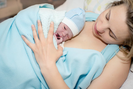Young beautiful woman with a newborn baby after birthの写真素材