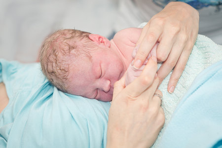 Young beautiful woman with a newborn baby after birthの写真素材
