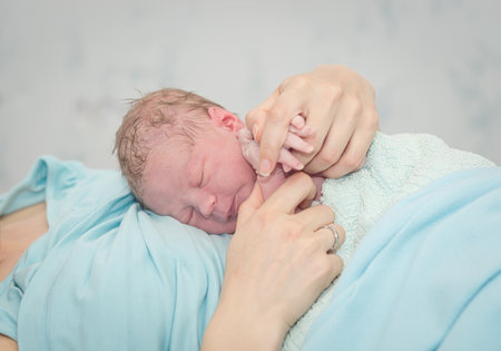 Young beautiful woman with a newborn baby after birthの写真素材