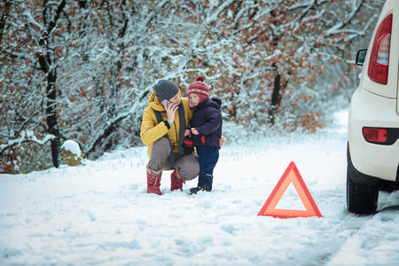 woman with a child on the winter road. emergency signの写真素材