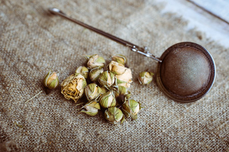 Flower tea with pink buds with tea infuser. Studio.の写真素材