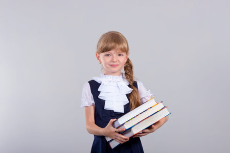 Cute beautiful schoolgirl with books in the studio