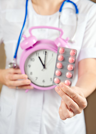 Doctor with pills in hand. alarm clockの写真素材