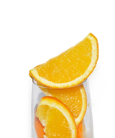 Glass with lobule orange fruits isolated on white backgroundの写真素材