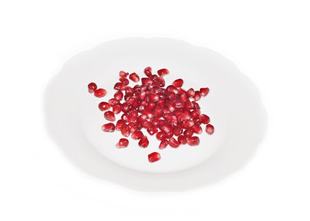 Pomegranate seeds on a plate, isolated on the white backgroundの写真素材