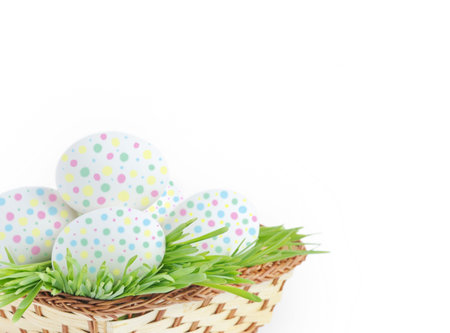 Painted Easter eggs in basket, isolated on white background