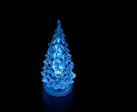 Blue luminous Christmas tree on black background
