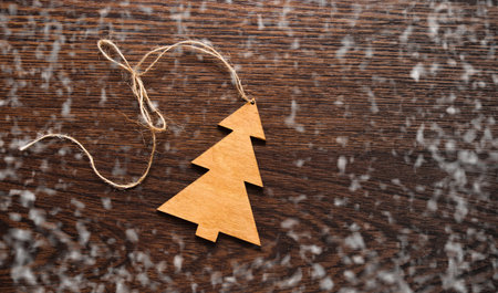 Handmade wooden Christmas tree on wooden background. Christmas toy, gift or souvenir. Christmas greeting card - space for your text.の写真素材