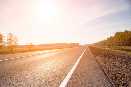 The picturesque landscape and the Sunrise over the road. Asphalt road with marking. With the blur.の写真素材
