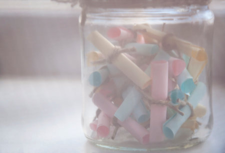 Glass jar with colored notes with blur and toningの写真素材