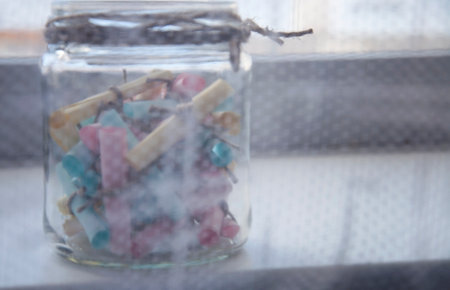 Glass jar with colored notes with blur and toningの写真素材