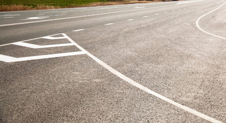 The picturesque landscape and the Sunrise over the road. Asphalt road with marking. With the blur.