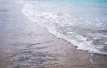 Soft wave of blue ocean on a sandy beach. With the blur. Toning.の写真素材