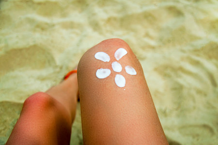 Legs of a girl lying on a beach deckchair by the sea. The sun, painted on sunburnt skin of the foot...
