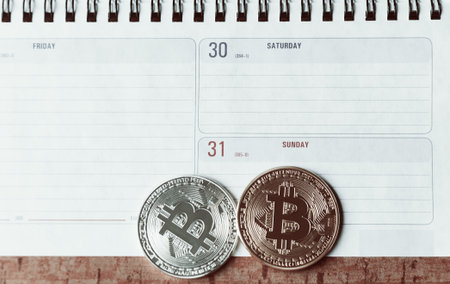 Two bitcoins  are lie on the planing. On the calendar are the last days of December 2017. The concept of crypto currencies.の写真素材