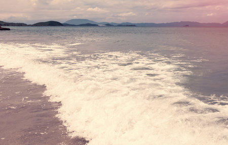 Soft wave of blue ocean on a sandy beach. With the blur. Toning.