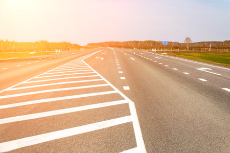 The picturesque landscape and the Sunrise over the road. Asphalt road with marking. With the blur and bright sunlight.の写真素材