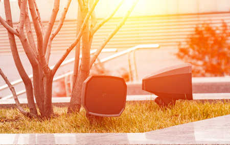 Modern loudspeakers installed in the park near the stairs, strewn with autumn leavesの写真素材