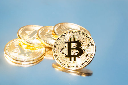 Several coins of bitcoins lie on the keyboard. Bright glow, toning and blurring. The concept of...
