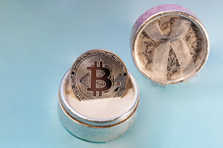 Coin bitcoin in a gift box for a ring or jewelry. The concept of crypto currency. The best gift for the holiday. A gift in Christmas. On blue background.の写真素材