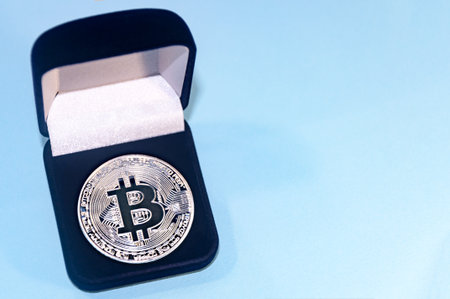 Coin bitcoin in a gift box for a ring or jewelry. The concept of crypto currency. The best gift for the holiday. A gift in Christmas. On blue background.の写真素材