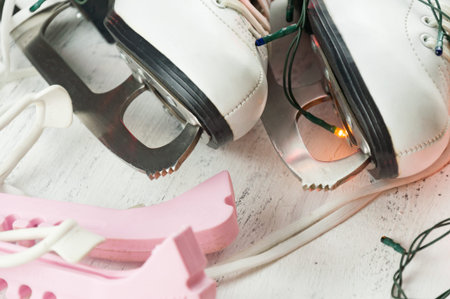 Vintage white female skates for figure skating, on a light wooden background