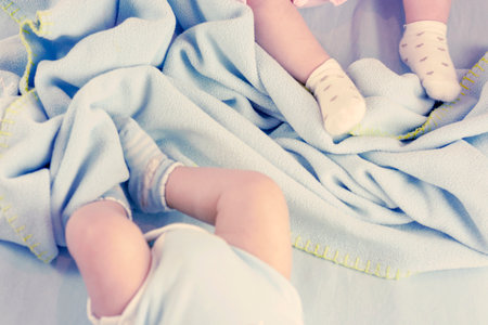 Young father with his newborn twins lying in bed. Young father with his newborn twins lying in bed. Selective focusの写真素材