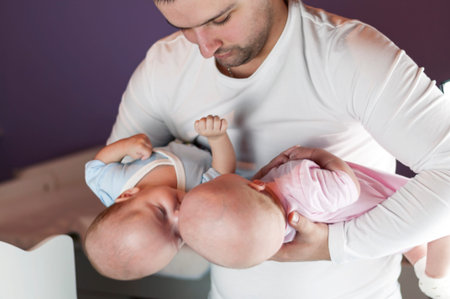 Young father with his newborn twins. Selective focus