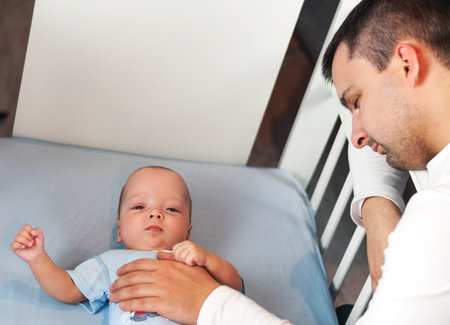 Young dad is tired of putting a small child to bed. Dad and son fatherly care concept. Selective focusの写真素材