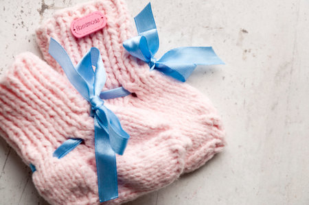 DIY Knitted pink warm wool socks for a newborn girl. Selective focus