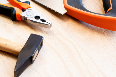 Hammer, nails and pliers lie on a wooden background. Construction Tools Selective Focus