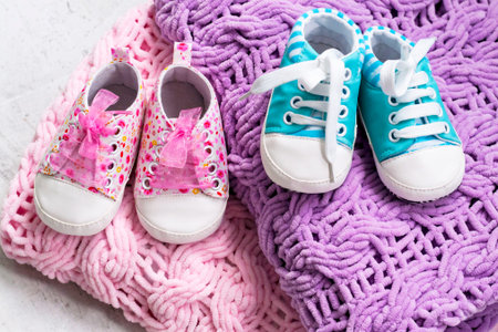 Baby booties pink and blue on a knitted bright microfiber rug. Ivf pregnancy conceptの写真素材